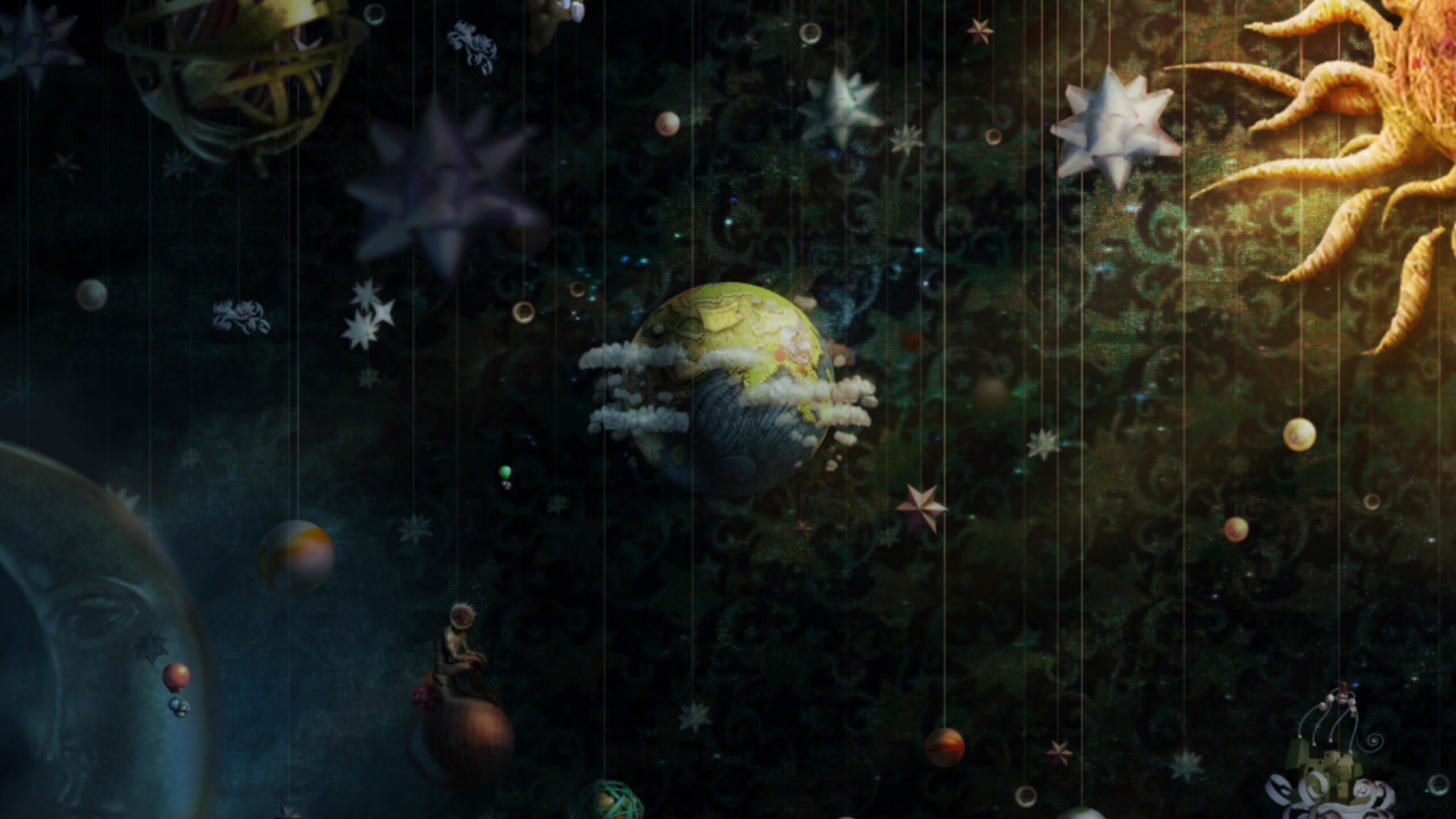 LittleBigPlanet artwork showing a fabric-covered planet, hanging paper stars, small suspended objects and a large stitched sun against a dark patterned backdrop.